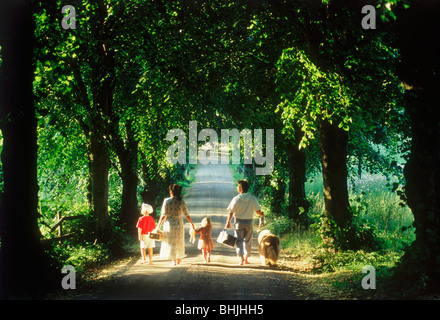 Family of five with dog on tree lined country road in Sweden Stock Photo