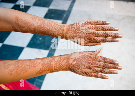 A new bride holds out her hands that are decorated in henna tattoos. Stock Photo