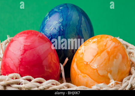 Three Easter Eggs in a Basket Drei bunte Ostereier in einem Korb Stock Photo