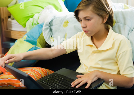 Preteen boy using laptop computer Stock Photo