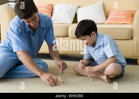 Father and son playing pick up sticks Stock Photo