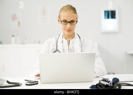 Female doctor using laptop at desk Stock Photo