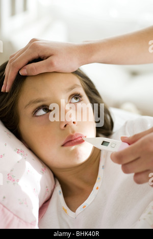 Mother checking daughter's temperature, caressing forehead, cropped Stock Photo