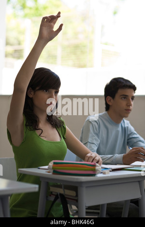 High school student raising hand in class