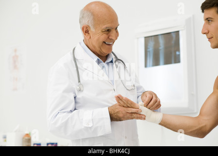 Doctor bandaging patient's wrist Stock Photo