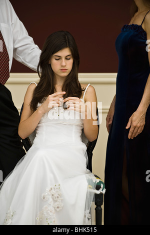 Teenage girl in formal gown bored at formal social event Stock Photo