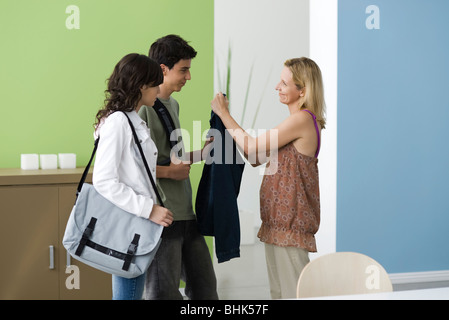 Teenagers going out, mother reminding son to wear jacket Stock Photo