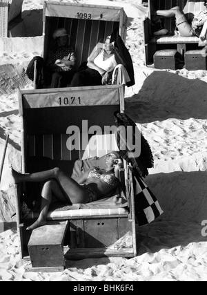 bathing, lido / open-air bath, holidaymakers in roofed wicker beach chairs on the beach at Westerland, Sylt, Germany, 1974, Stock Photo