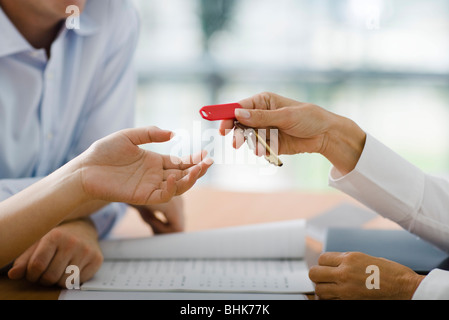 Hotel receptionist handing room key to guest Stock Photo