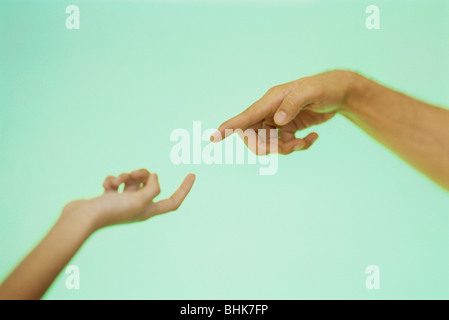 Two hands reaching toward each other with index fingers extended Stock Photo