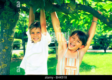 BOY AND GIRL PLAYING IN A PARK Stock Photo