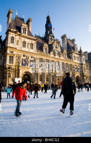 Ice rink and winter ice skaters in front of the Hôtel de Ville / City Hall in Paris, France. Stock Photo