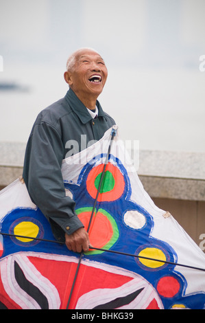Old man with a large kite on the Huang Pu River waterfront in Shanghai, China, Asia Stock Photo