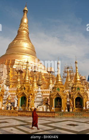 Burmese monk seemingly having all of the famous Shwedagon Pagoda in Yangon to himself. Stock Photo