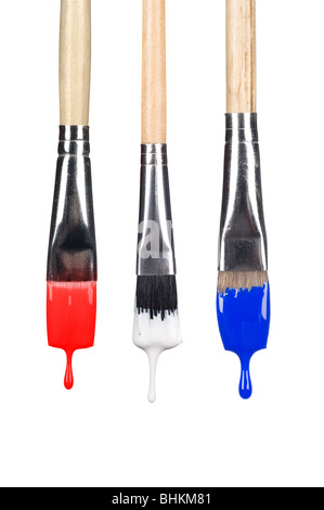 A set of dripping paint brushes with red, white and blue paint falling from the bristles. Stock Photo