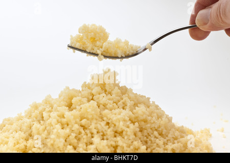 Fork lifting cooked Couscous from a pile Stock Photo