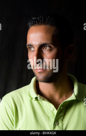 Handsome young man in deep thinking against a black background Stock Photo