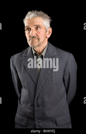 Portrait of a senior man in suit, isolated over black background Stock Photo