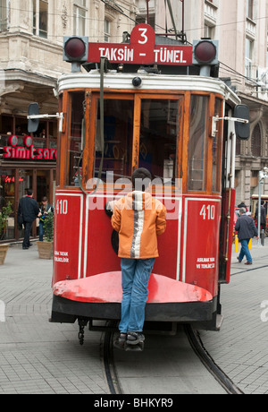 A boy hangs on to a tram in Istiklal Caddesi in the Beyoglu shopping area of Istanbul Stock Photo