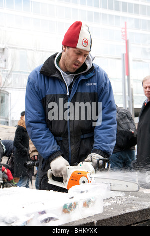 A man cutting off cubs of ice with toys inside to be handed out to kids Stock Photo