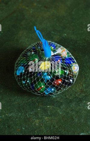 Traditional children glass marbles inside a net Stock Photo