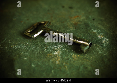 Old metal key on the ground outdoors Stock Photo