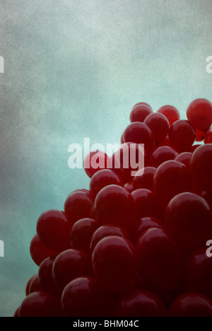 Bunch of red balloons against a dramatic sky Stock Photo