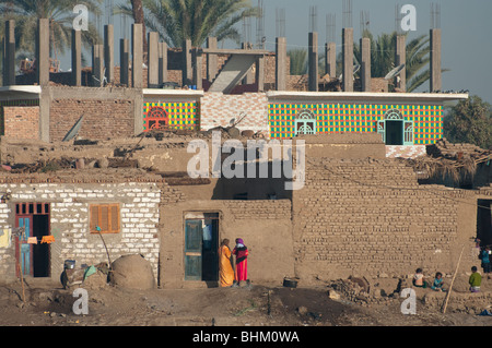 View of houses on the bank of the river Nile, near Luxor, Egypt with local people in colourful clothes Stock Photo