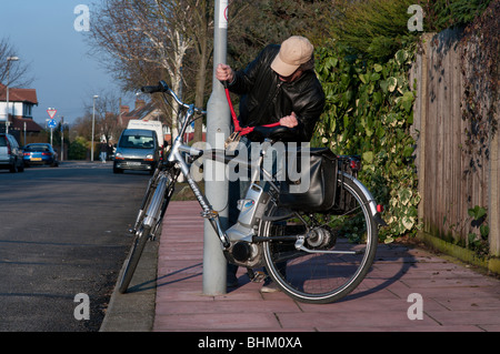 Bicycle thief takes wire cutters to steal chained up bike Stock Photo