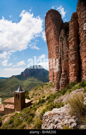 'Las Peñas de Riglos' or 'Mallos de Riglos' rock towers  on hill at Riglos, Aragon, Huesca Province, Spain, with Village below Stock Photo