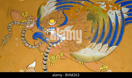 Mural of a Garuda painted in traditional Bhutanese style on a wall in Wangdichholing Dzong. It has a snake, naga, in its beak. Stock Photo
