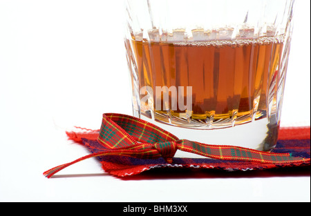 Scottish Malt Whiskey in crystal glass resting on tartan coaster. Stock Photo