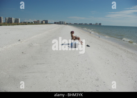 Woman sunbathing and reading book at the Tiger Tail beach (Marco Island, Florida, USA) Stock Photo