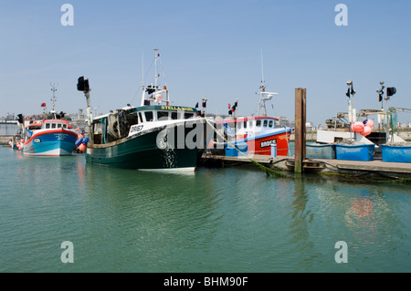 Fishing boats in the Royal Harbour at Ramsgate, Kent, United Kingdom. The large crates are used to store the nets Stock Photo