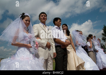 Kazakh brides and grooms during a simultaneously mass wedding ceremony in Arai park in Nur-Sultan or Nursultan capital of Kazakhstan Stock Photo