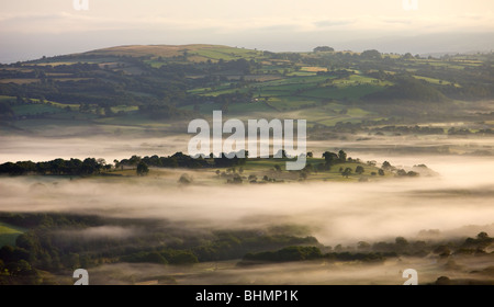 Early morning mist hanging over rolling farmland near Llangadog, Brecon Beacons National Park, Carmartenshire, Wales, UK. Stock Photo