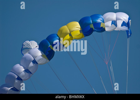 A yellow white, and blue parachute against a blue sky during Bridge Day at the New River Gorge, Fayetteville, WV. Stock Photo