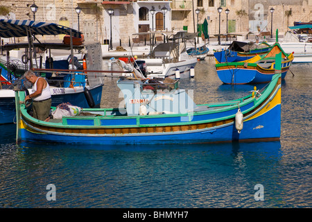 Brightly painted Luzzu fishing boat moored in Saint Julian’s Harbour, Spinola Bay, Saint Julian’s, Malta Stock Photo
