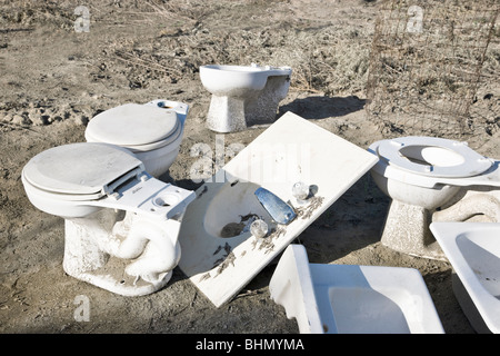 Discarded porcelain toilets & sinks. Stock Photo