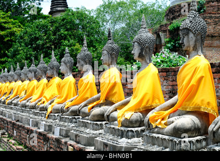 Aligned buddha statues with orange bands, Thailand Stock Photo