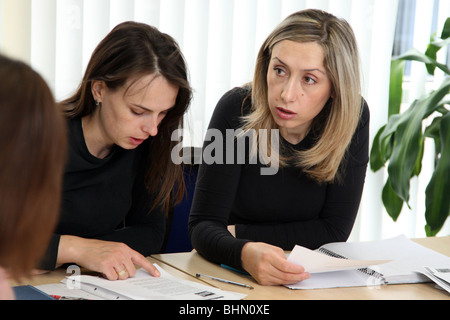 Two women mature students studying in a college classroom, both in their late twenties. Learning English, from Eastern Europe. Stock Photo