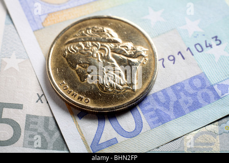 The bust of the writer Homer (Omiros) on a 50 drachma coin lying on euro banknotes. Stock Photo