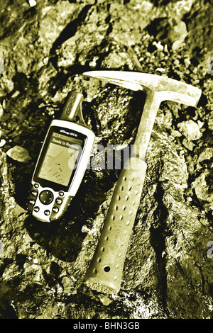 Mining exploration; geologists rock hammer and GPS unit on mineral rich rock background Stock Photo