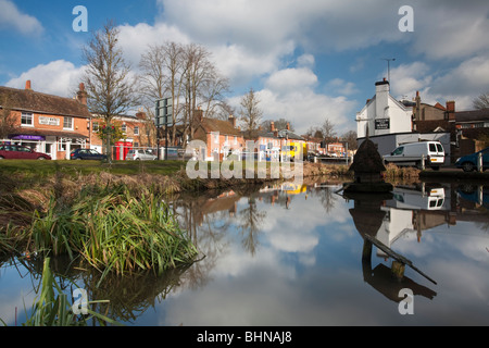The Hampshire Village of Hartley Wintney reflected in the village duckpond, Uk Stock Photo