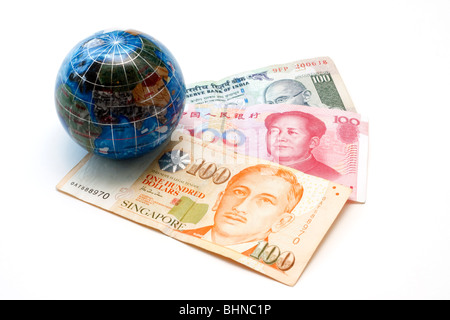 Asian currencies with miniature globe. Singapore 100 dollar bill, Chinese 100 yuan and Indian 100 rupees. Stock Photo