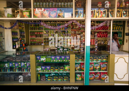 India, Kerala, Munnar, tea and spice souvenir stall, man serving Stock Photo