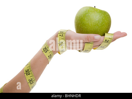 Green apple and measuring tape with a hand as a diet concept Stock Photo