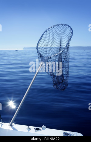 men fishing with triangular scoop net early morning at sunrise near iconic  U-Bein Bridge, on shallow Lake Taungthamanin, Amarapura, Mandalay, Myanmar  Stock Photo