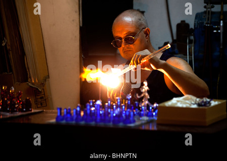 A craftsman in Mdina in Malta works on a glass chess set Stock Photo
