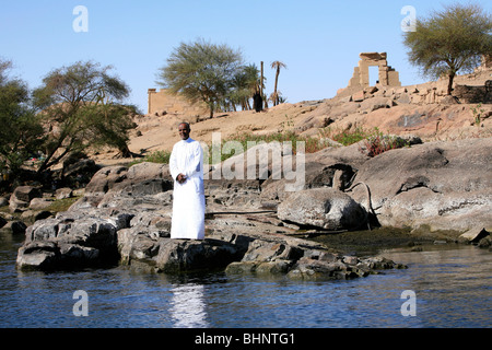 Nubian man and woman standing in front of the Temple of Khnum on Elephantine Island in Aswan, Egypt Stock Photo